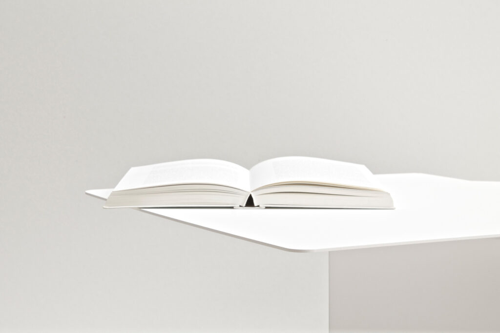 A photography of the minimalist side table with a book