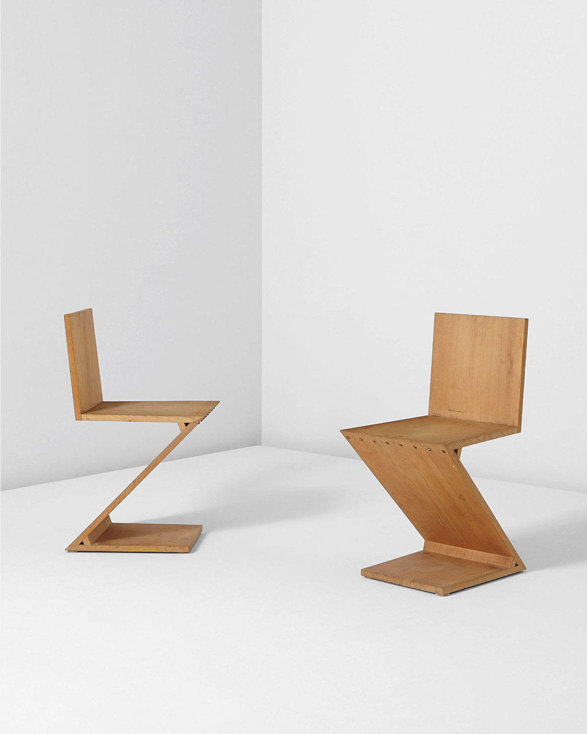 Gerrit Thomas Rietveld, Pair of 'Zig Zag' chairs, 1965-1969, Elm, brass, Each: 74.6 x 36.8 x 44.5 cm © Image Courtesy Phillips Auction