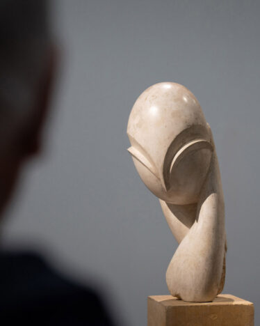 A man is looking at a version of “Mlle Pogany” by Constantin Brâncuși. Image from the exhibition “Constantin Brâncuși” at the Center Pompidou 2024 © Photography by Sarah Dorweiler / Aesence