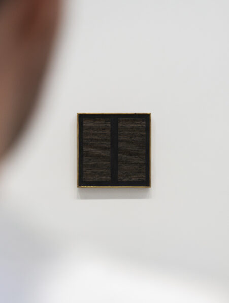 A man looking at an artwork by Agnes Martin, on view at 'Minimal' at Bourse de Commerce, Paris, 2025 © Photography by Aesence / Sarah Dorweiler